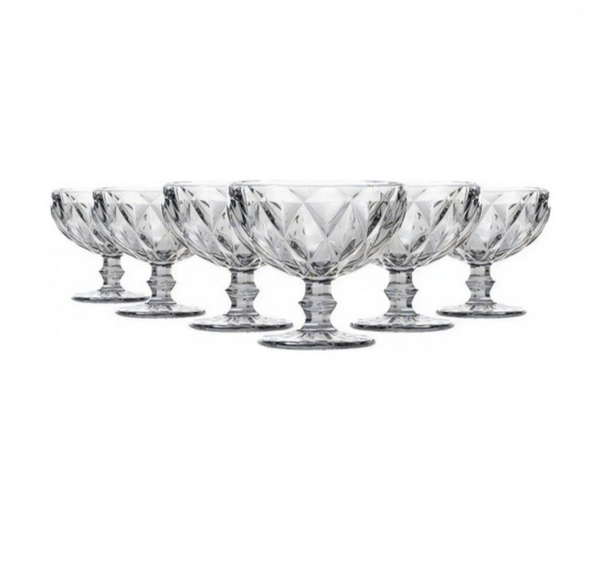 Six crystal dessert bowls arranged in a row against a white background.